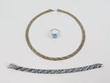 un gros plan sur un collier, un bracelet et une bague posés sur une table