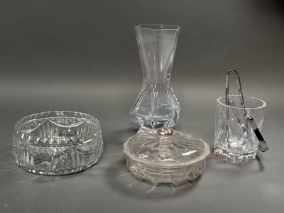 un vase en verre, un bougeoir et un verre posés sur une table