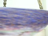 a blue and purple bowl hanging from a chain