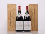 two bottles of red wine sit next to a wooden box
