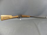 an old rifle with a wooden handle on a gray surface