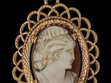 un camée ancien représentant une femme de profil, avec des tresses autour du cou