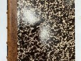 un vieux livre dont les pages, parsemées de taches noires et blanches, se détachent sur une couverture blanche