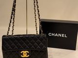 a chanel black quilted bag with gold hardware