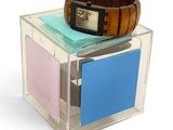 a watch sitting on top of a stack of cards in a clear box