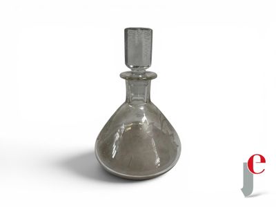 a glass bottle that is sitting on a white surface