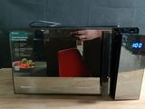 un micro-ondes posé sur une table à côté d'une chaise rouge