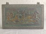 a bronze plaque with a horse and carriage scene on it