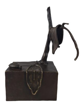 une image représentant une statue en bronze d'un oiseau posé sur un tronc