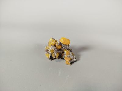 a close up of a bunch of small yellow flowers on a white surface