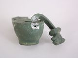 a small green pot with a bone sticking out of it