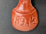 a small red vase with an elephant design on it