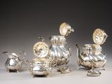 an image of a group of silver teapots and saucers