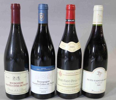quatre bouteilles de vin sont alignées sur une table