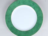 a plate with a green rim on a white table