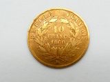 gros plan d'une pièce d'or sur une surface blanche