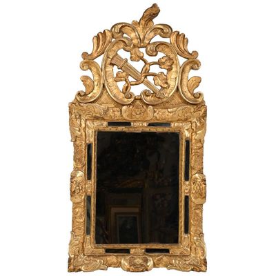 un miroir doré surmonté d'un oiseau