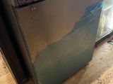 a broken refrigerator sitting on the floor in the kitchen