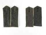 two pieces of black felt with zippers on a white surface