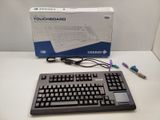 a keyboard and a mouse on a table with a box in the background