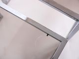a glass shower door with a metal frame in a bathroom