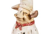 a statue of a dog wearing a chef ' s hat and scarf