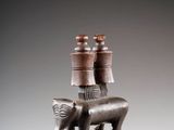 une image représentant une statue de chat portant des pots sur le dos