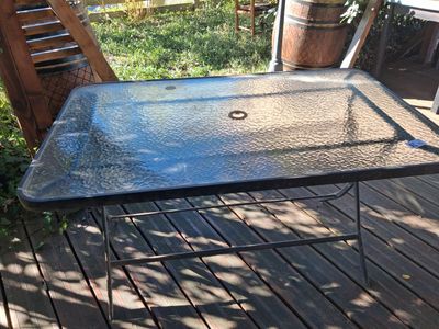 a glass table that is sitting on a wooden deck