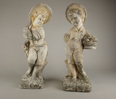 deux statues représentant un garçon et une fille tenant des paniers de fleurs