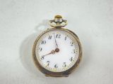 a gold pocket watch with a white face on a white surface