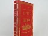 the book is red and gold with a picture of a boat on it