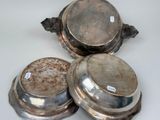 three silver dishes sitting on top of each other on a table