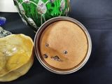 a jar with a face on it next to a green vase