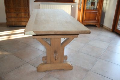 a wooden table in the middle of a tiled floor