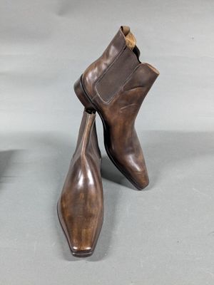 pair of men ' s brown leather ankle boots on a gray surface