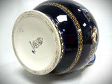 a blue and white vase with gold decoration on it