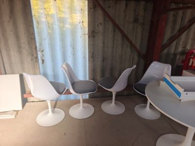 plusieurs chaises et une table dans une pièce, avec un livre posé dessus