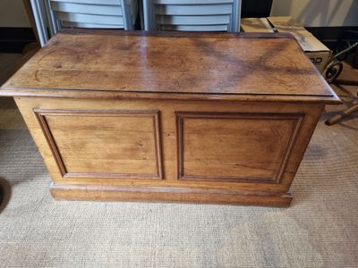 an old wooden chest sitting on top of a carpeted floor