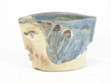 a blue and white bowl with a face on it
