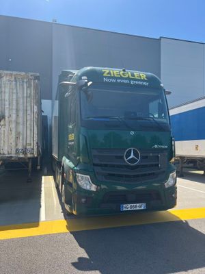 a green truck that is parked in front of a building
