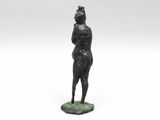 a bronze statue of a woman standing on a green base