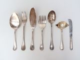 a lot of silver spoons and spoons on the table