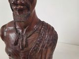 statue of a man with a hat on his head on a white surface
