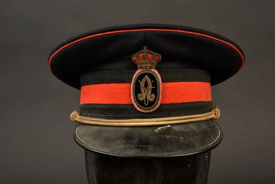 une image représentant un chapeau noir orné d'une bande rouge et d'une couronne