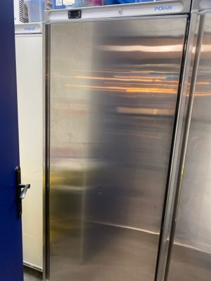 un réfrigérateur en acier inoxydable dans une cuisine avec une porte bleue