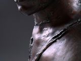 a bronze statue of a man with a chain around his neck
