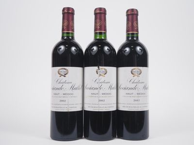 trois bouteilles de vin rouge posées l'une à côté de l'autre sur une surface blanche