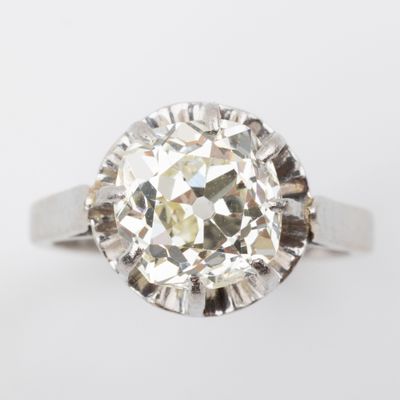 a close up of a diamond ring on a white surface