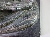 a statue of a man holding a fish on top of a stone block