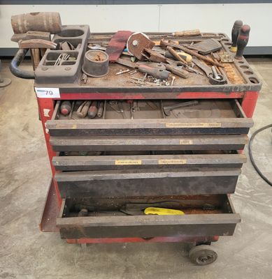 un chariot à outils sur lequel sont posés de nombreux outils, dans un garage